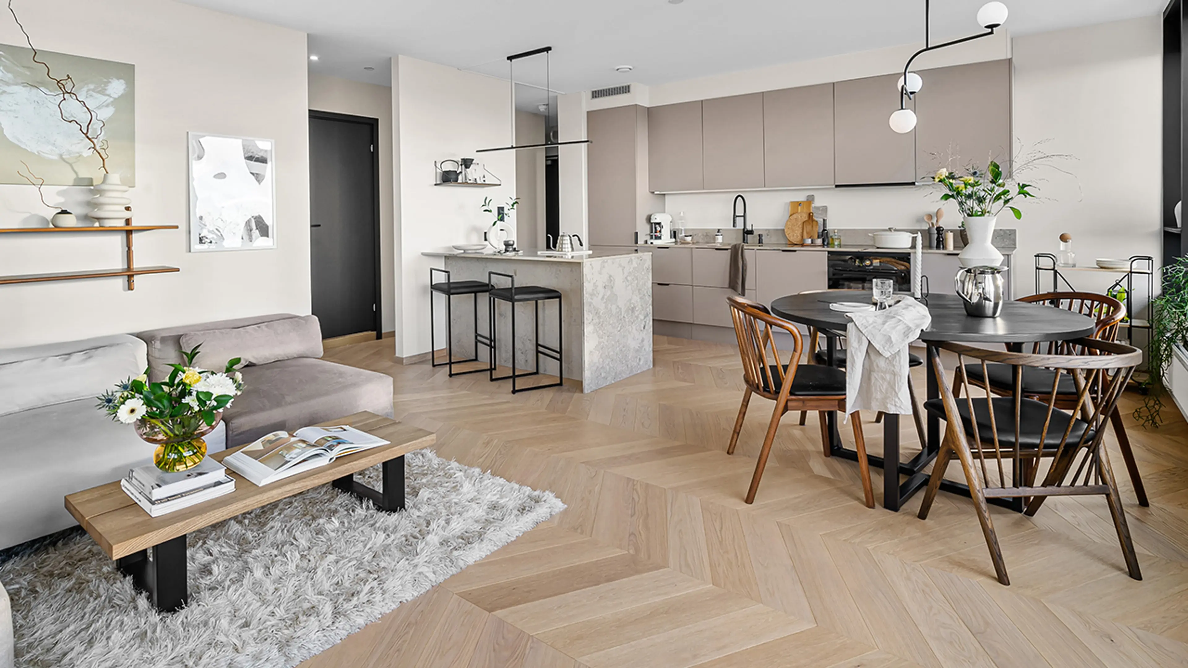 Chevron parkettgulv i leilighet med beige vegger og nordisk stil.