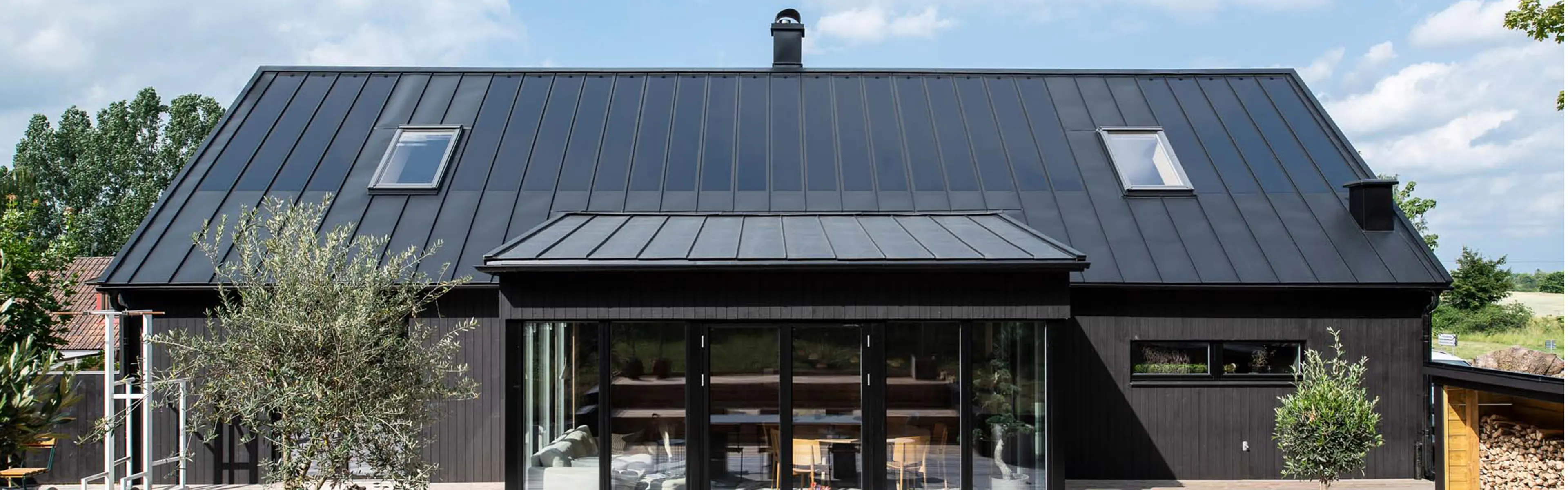 Svart hus med solceller på taket.