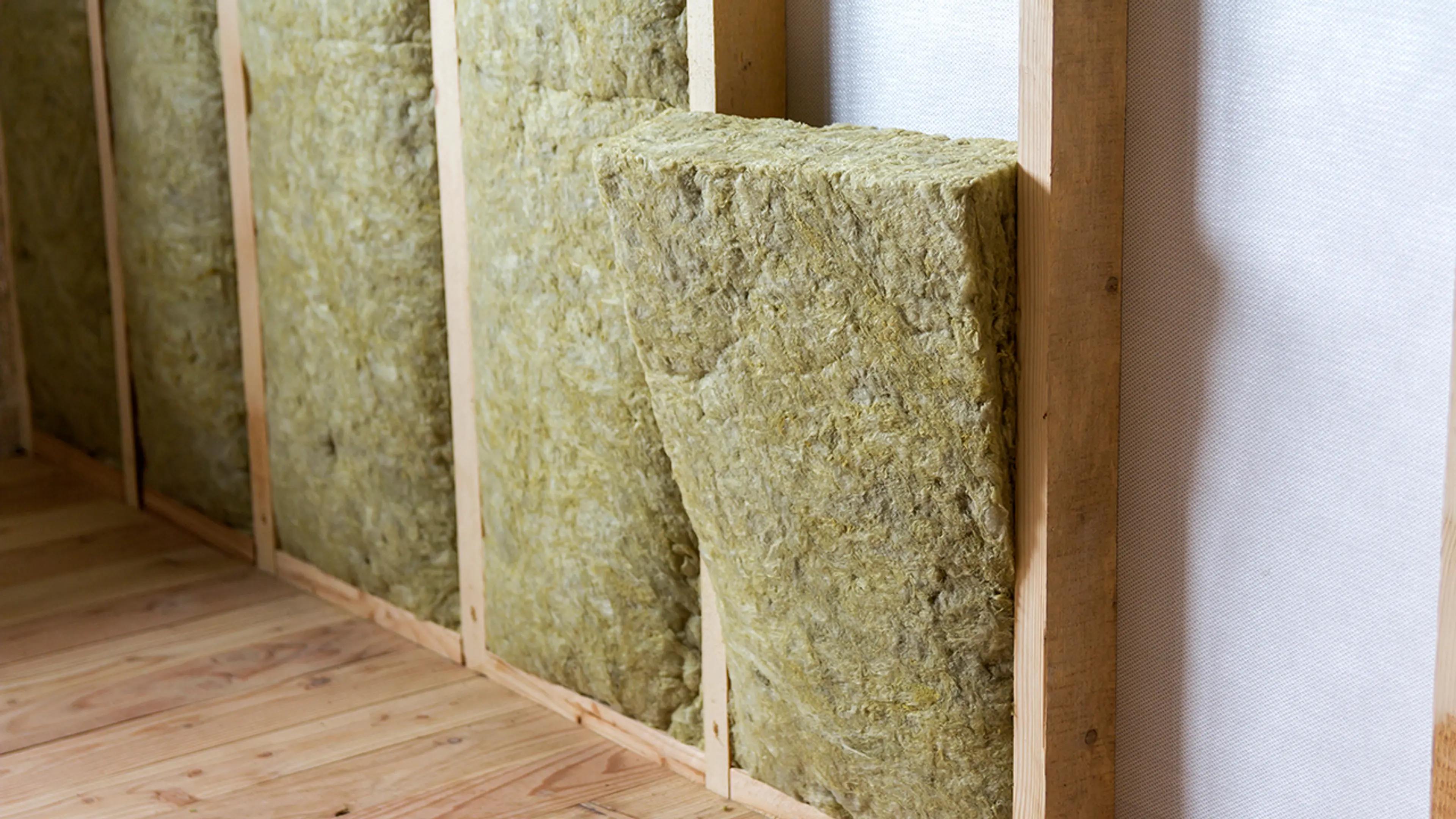 Isolasjon av steinull som er satt inn i innvendig vegg for etterisolasjon.