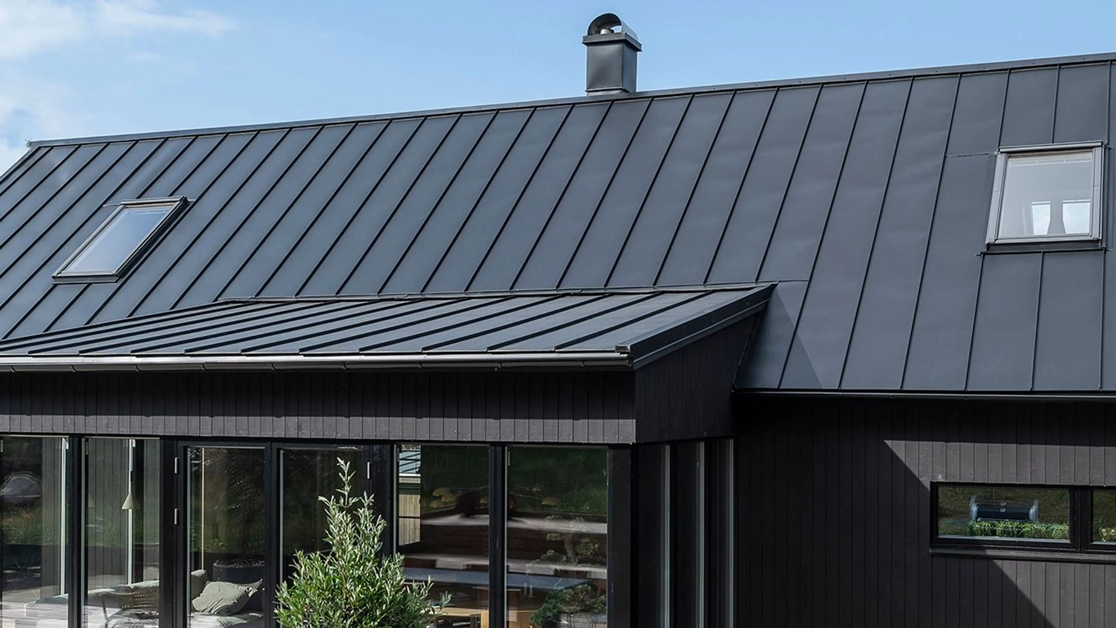 Nytt tak med takplater på sort hus.