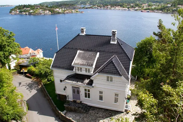 Klassisk sørlandsk villa ved sjøen med sort glasert takstein