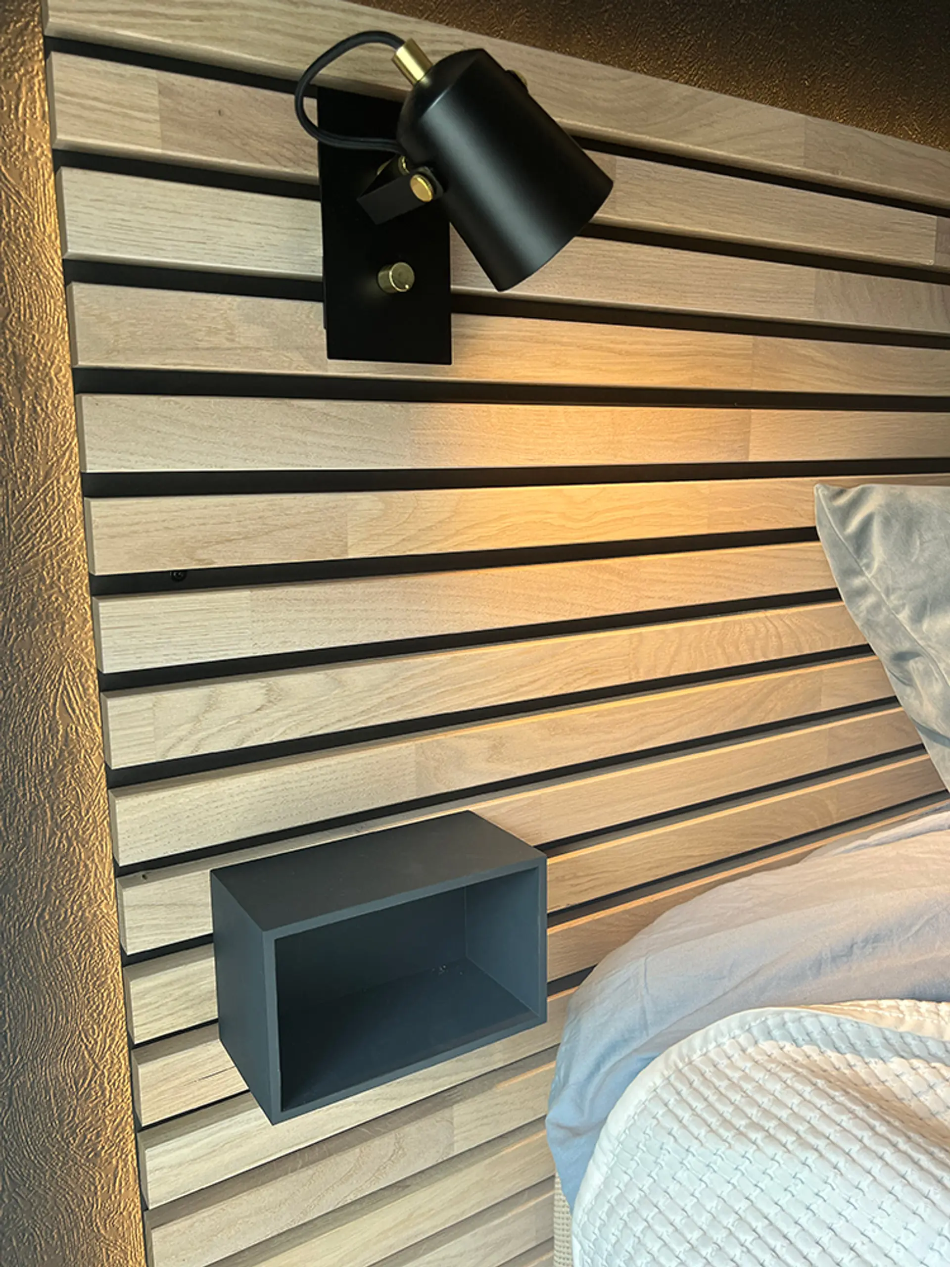 nærbilde av lampe og nattbord på DIY sengegavl av spiler