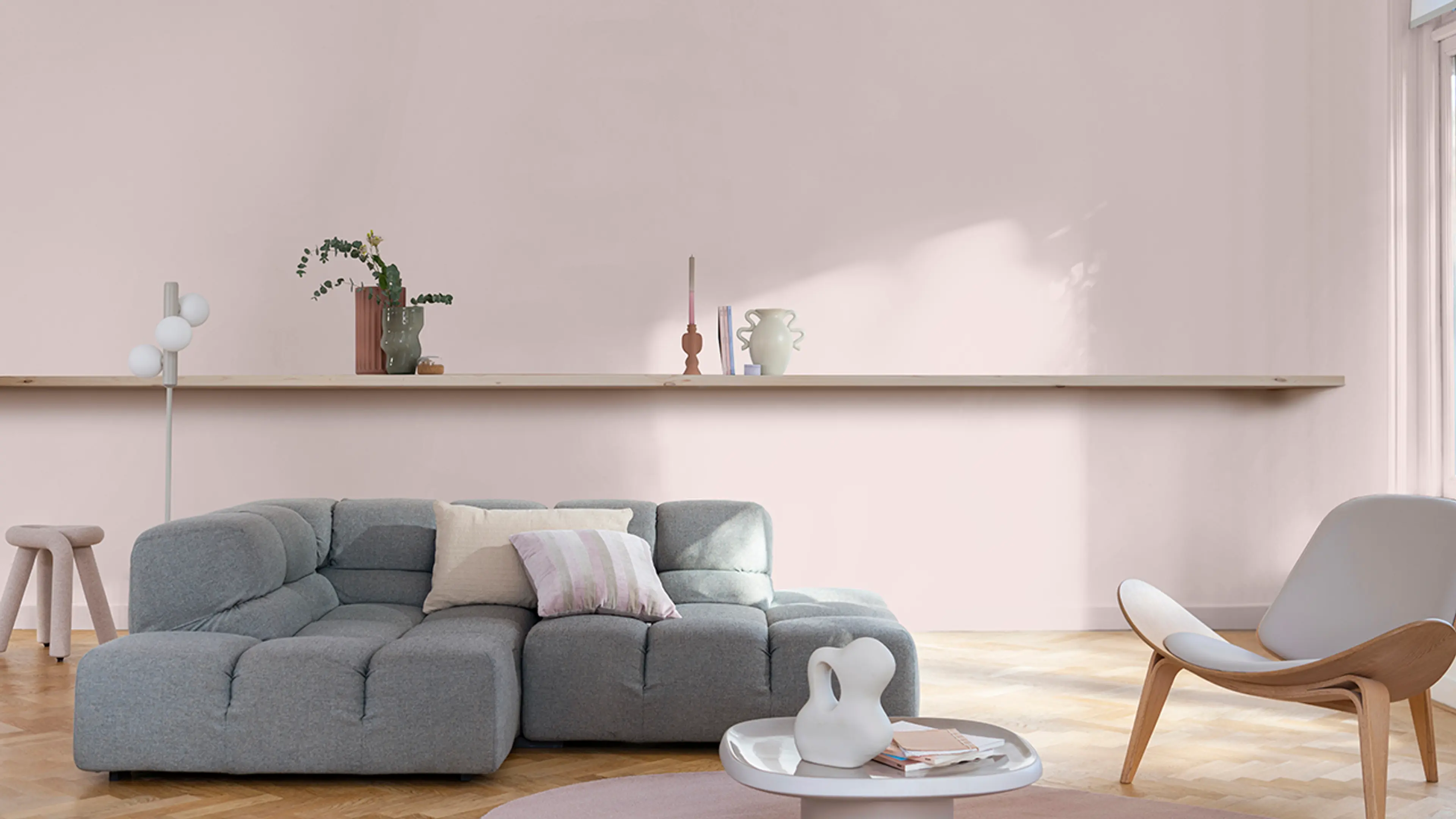 Stue med grå sofa og lenestol malt med årets farge fra Nordsjö: rosafargen Sweet Embrace.
