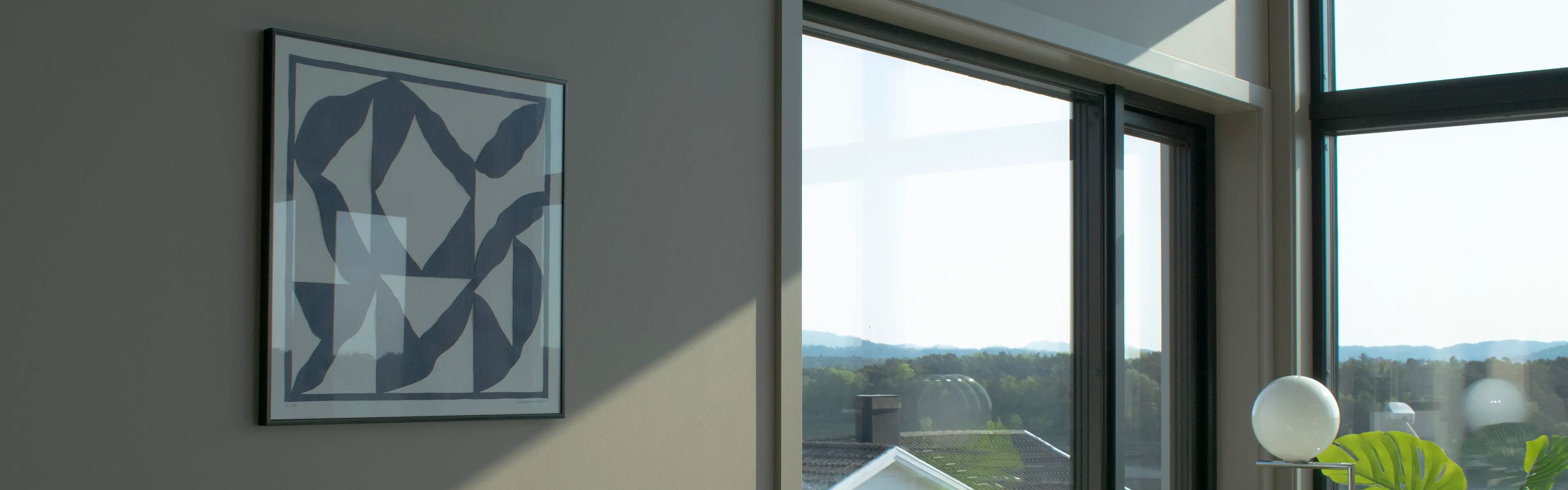 Gråbeige stue i moderne hus med glatte lister rundt vinduene.