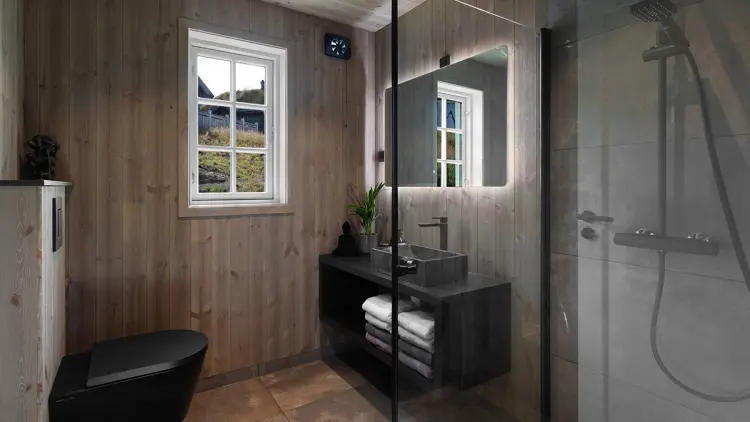 Hyttebad med trepanel på veggene og sorte baderomsmøbler og detaljer.