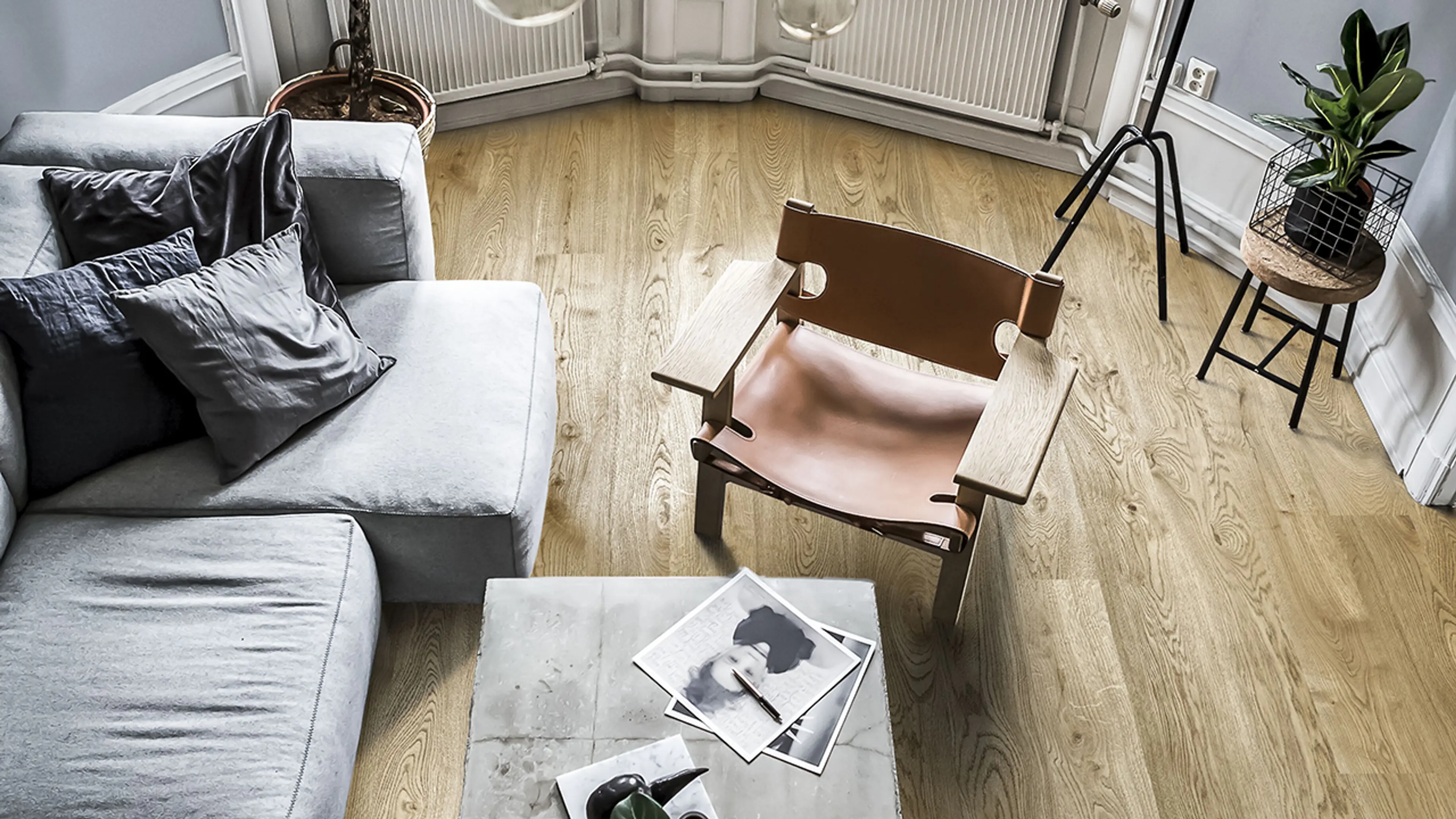 Kährs Aware gulv i stue med grå sofa og spanskestolen.