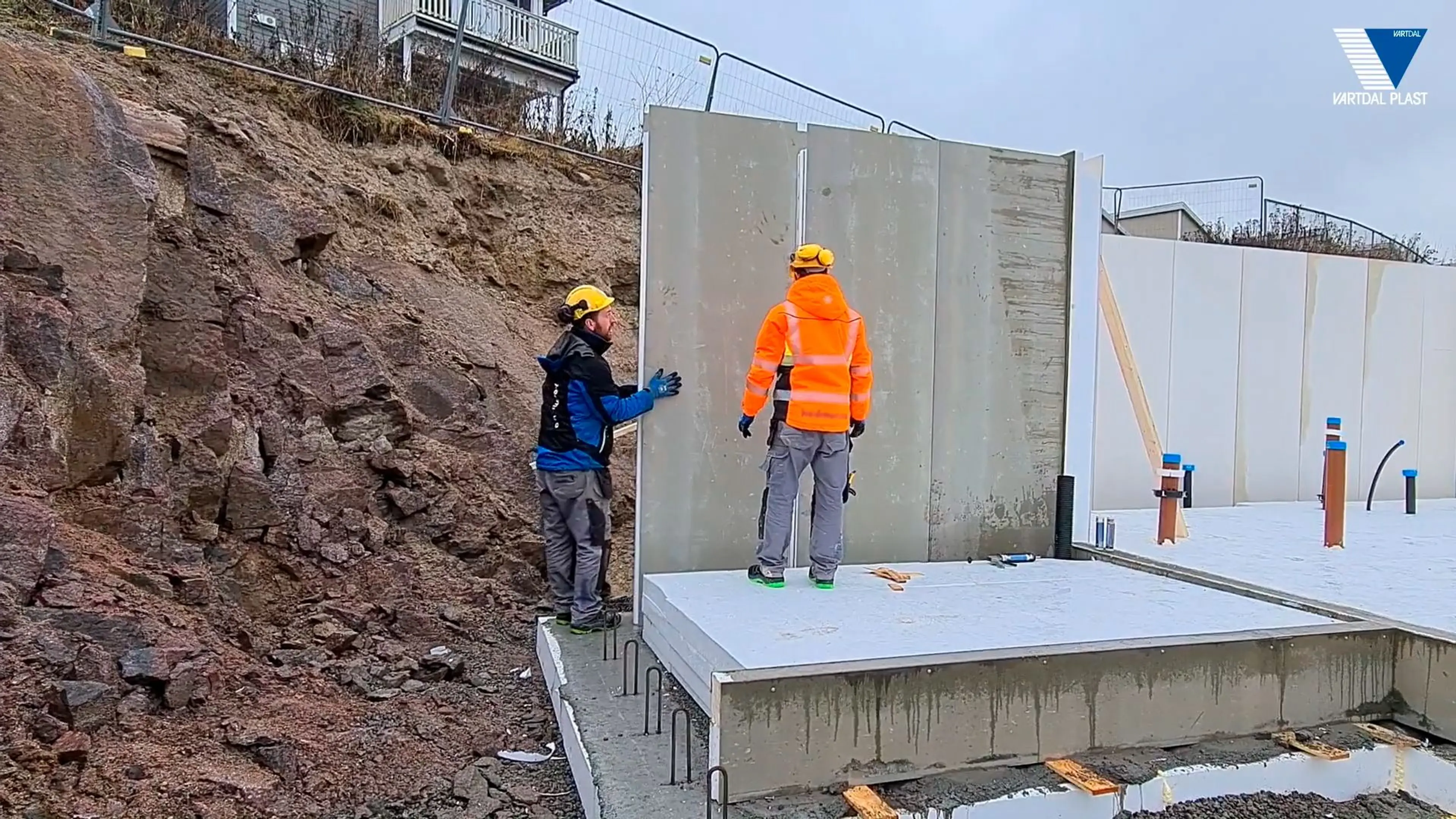 to håndverkere jobber med å sette opp en grunnmur på en byggeplass
