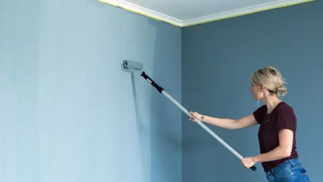 Kvinne som viser hvordan male innendørs.
