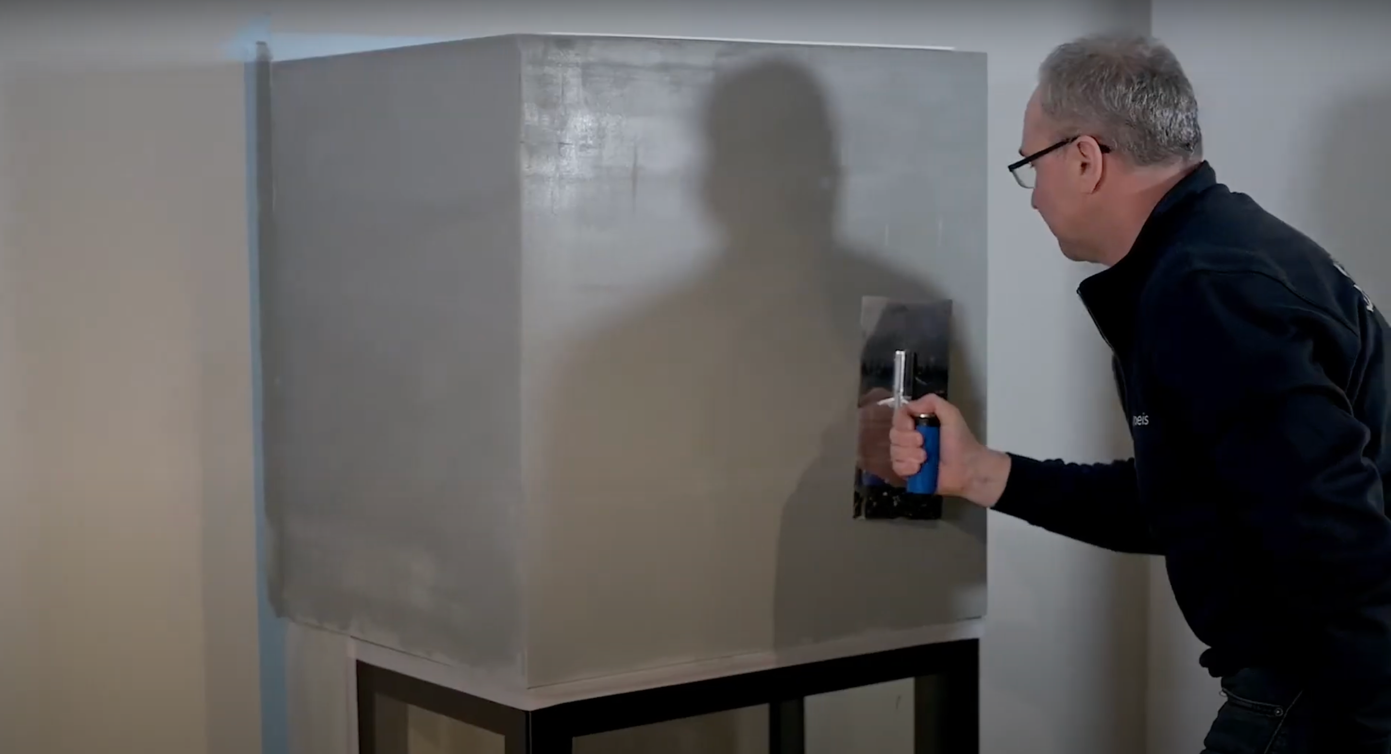 Mann som sparkler en peis før maling.