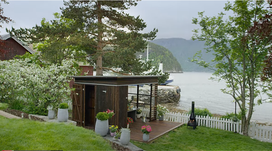 hagestue i tre nede ved strandkanten