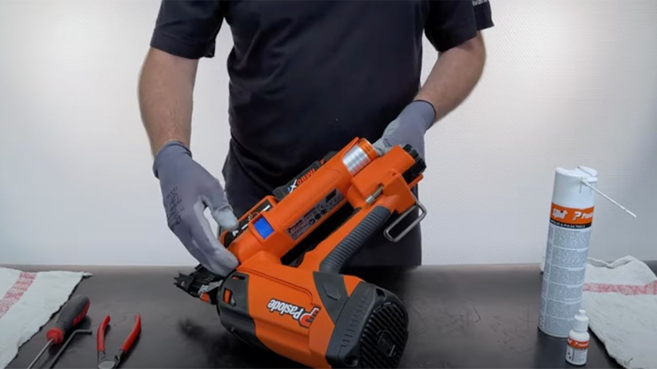 Person som renser Paslode verktøy med rensekit.