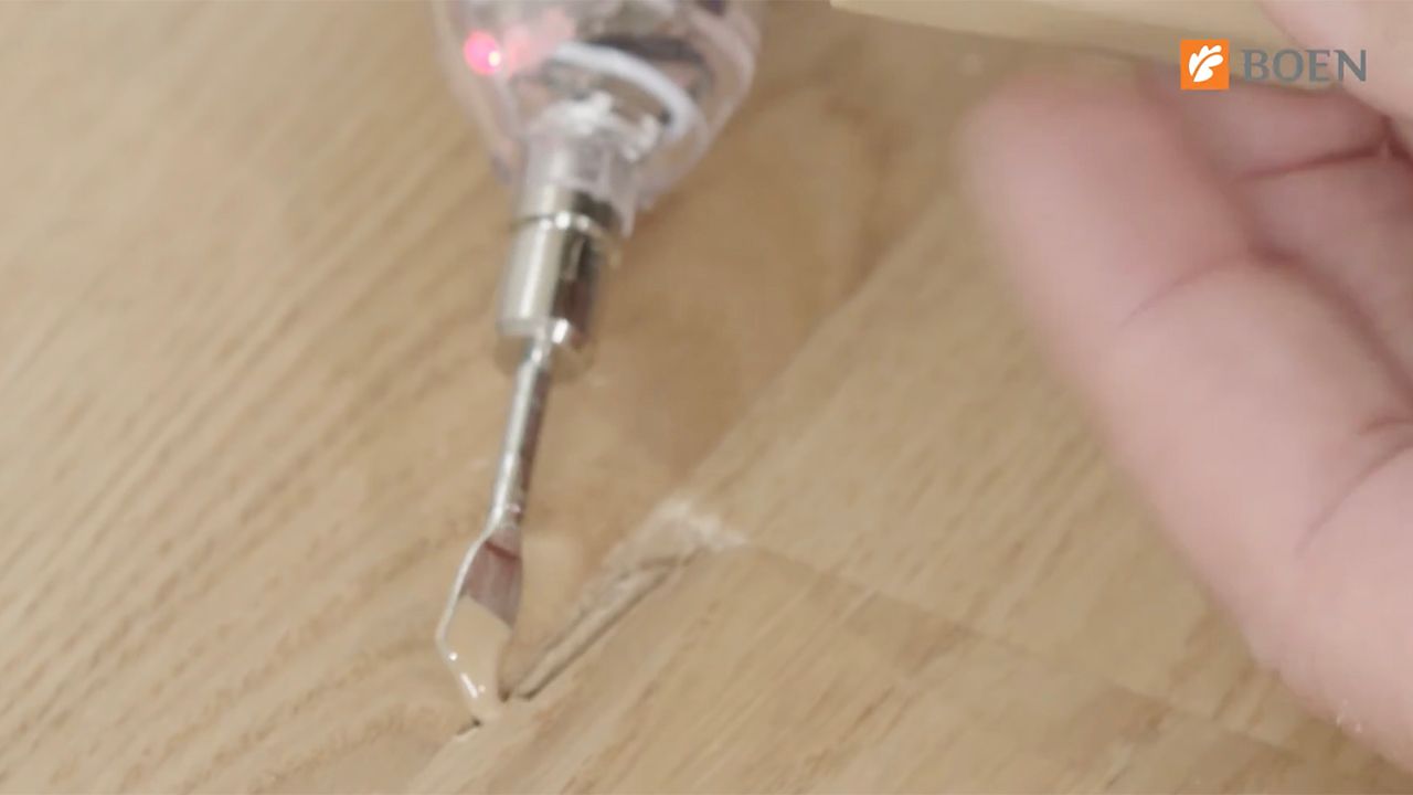 Skjermbilde fra video av hvordan man reparerer hakk i parkettgulv.