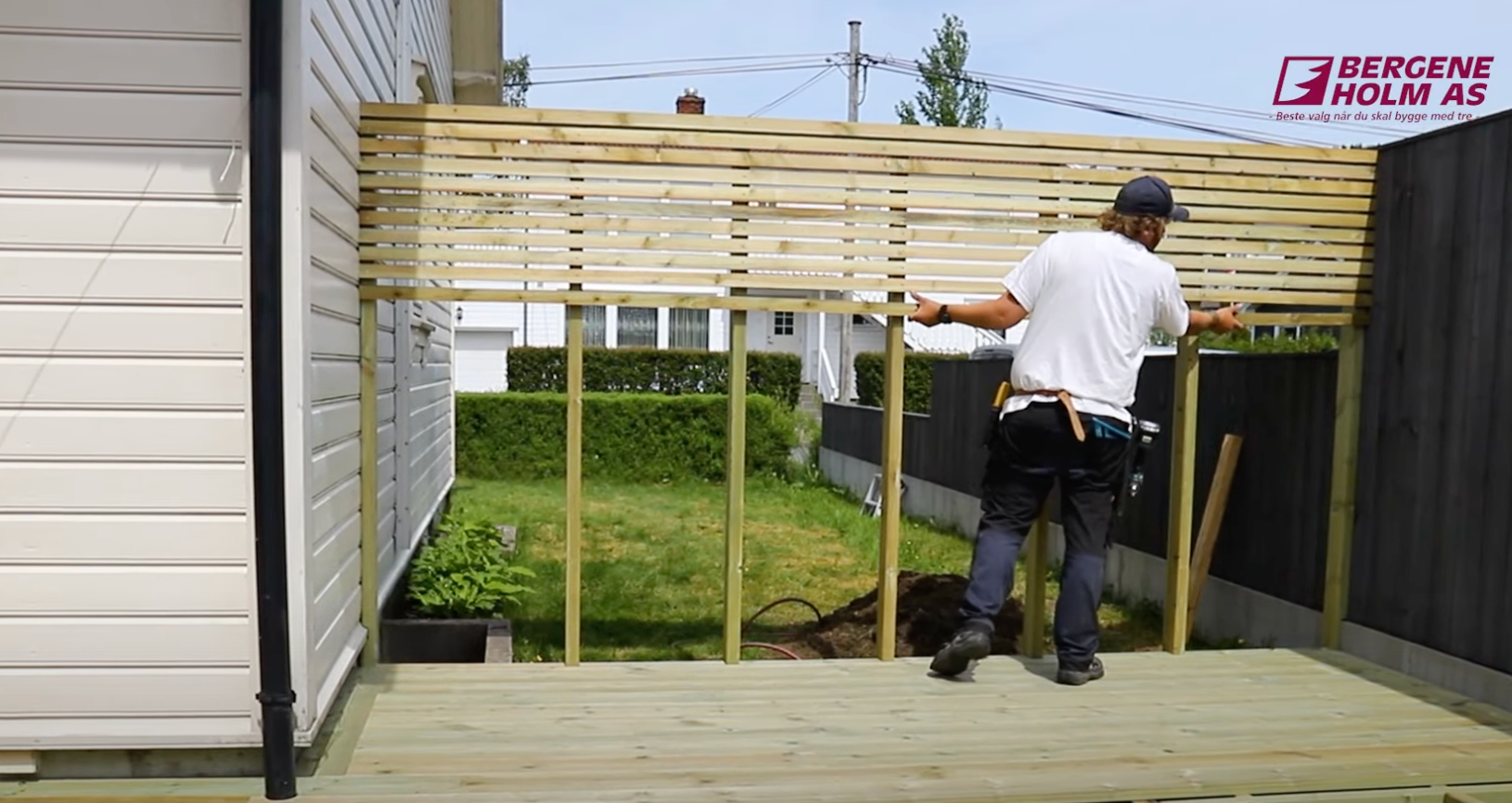 Mann setter opp spilevegg i hagen.