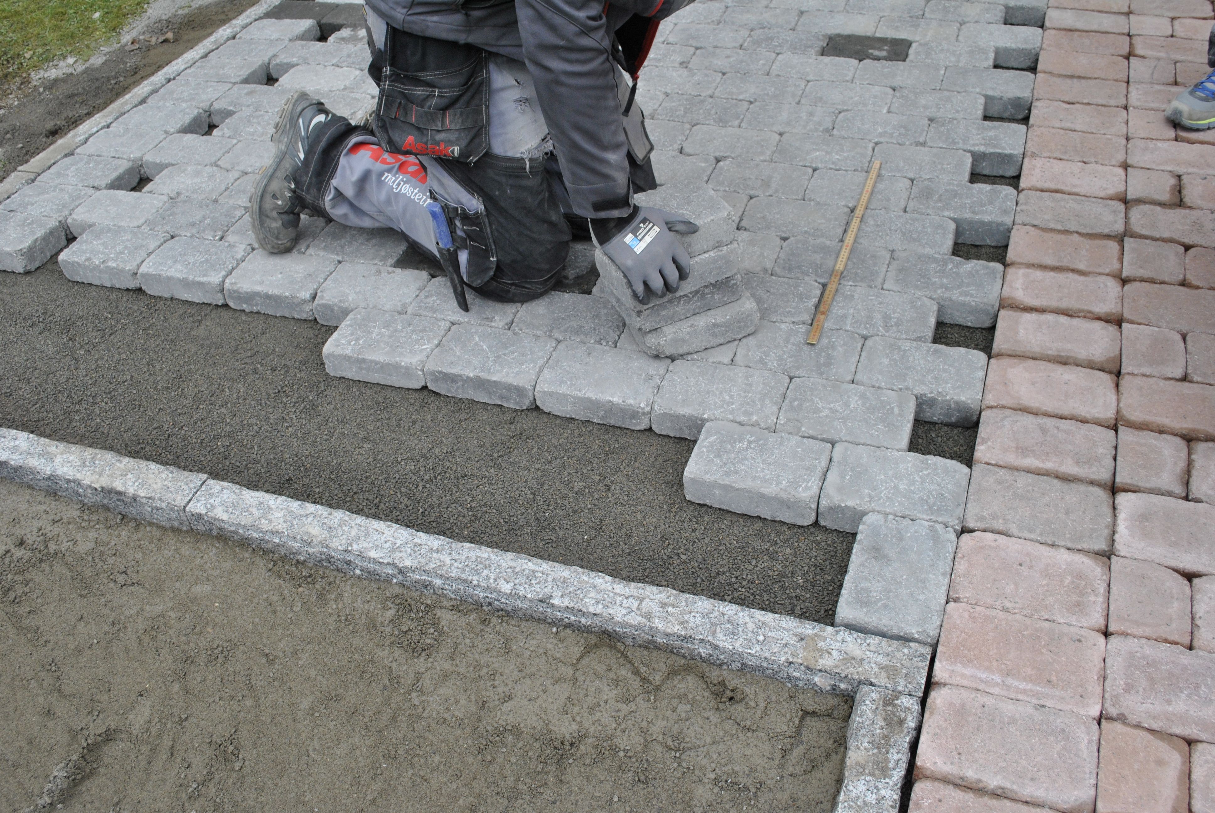 Mann viser hvordan man legger ASAK Herregård belegningsstein selv