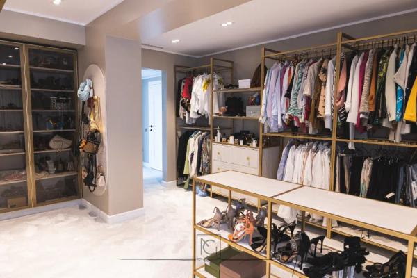 Dressing cu vitrine pentru încălțăminte și rafturi aurii cu haine colorate – Penthouse B. V., București