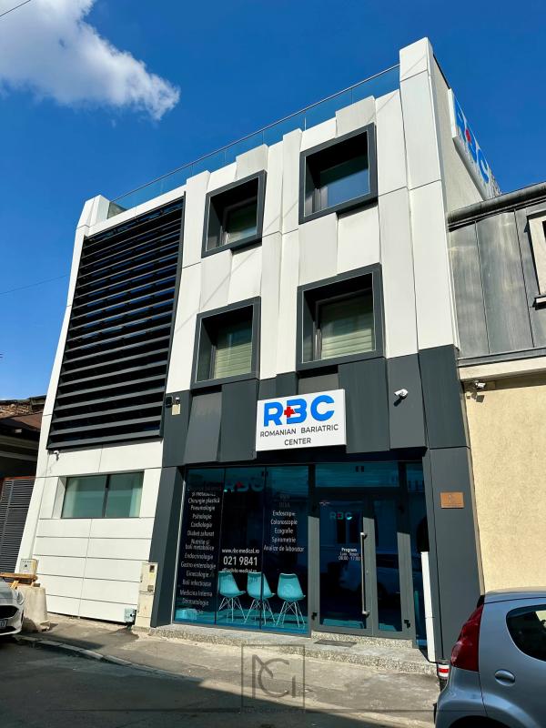 Fațada renovată cu panouri gri și albe, lamele negre și logo pe vitrina de la parter – Romanian Bariatric Center, București