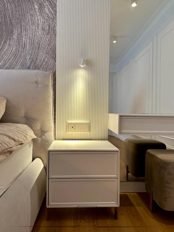 Noptieră albă iluminată cu LED lângă perete riflat și masă de toaletă – Casa A.A., București
