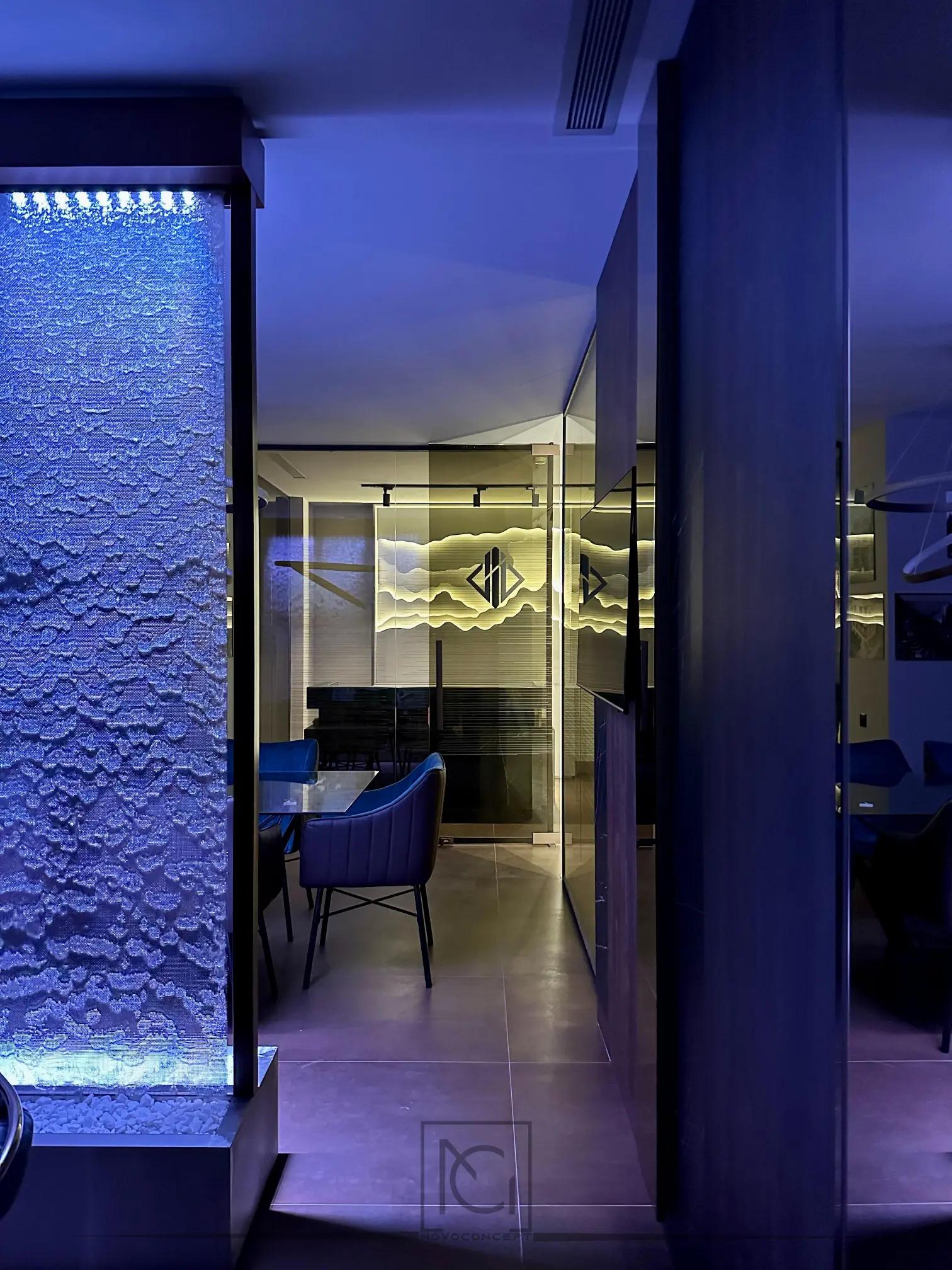 Coloană decorativă cu apă și bule în lumină albastră, lângă sala de ședințe