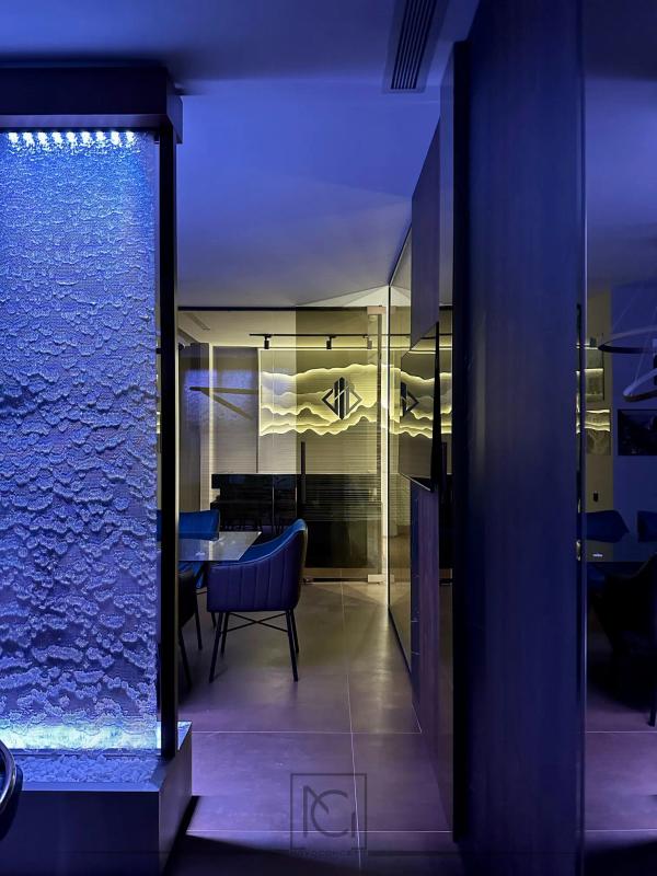 Coloană decorativă cu apă și bule în lumină albastră, lângă sala de ședințe