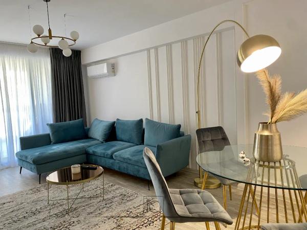 Living cu canapea de colț turcoaz, măsuță cu blat din sticlă și lustră cu globuri – Apartament A.T., București