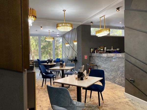 Restaurant cu lustre aurii, bar cu blat din marmură gri și scaune albastre din catifea