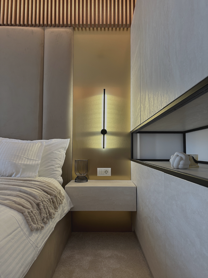 Cameră de hotel boutique cu tăblie tapițată bej, lamele din lemn și aplică liniară neagră