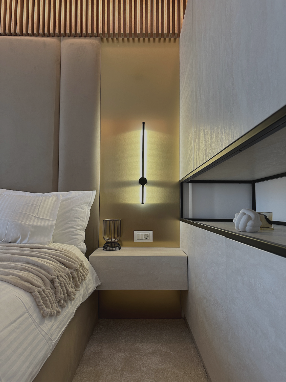 Cameră de hotel boutique cu tăblie tapițată bej, lamele din lemn și aplică liniară neagră