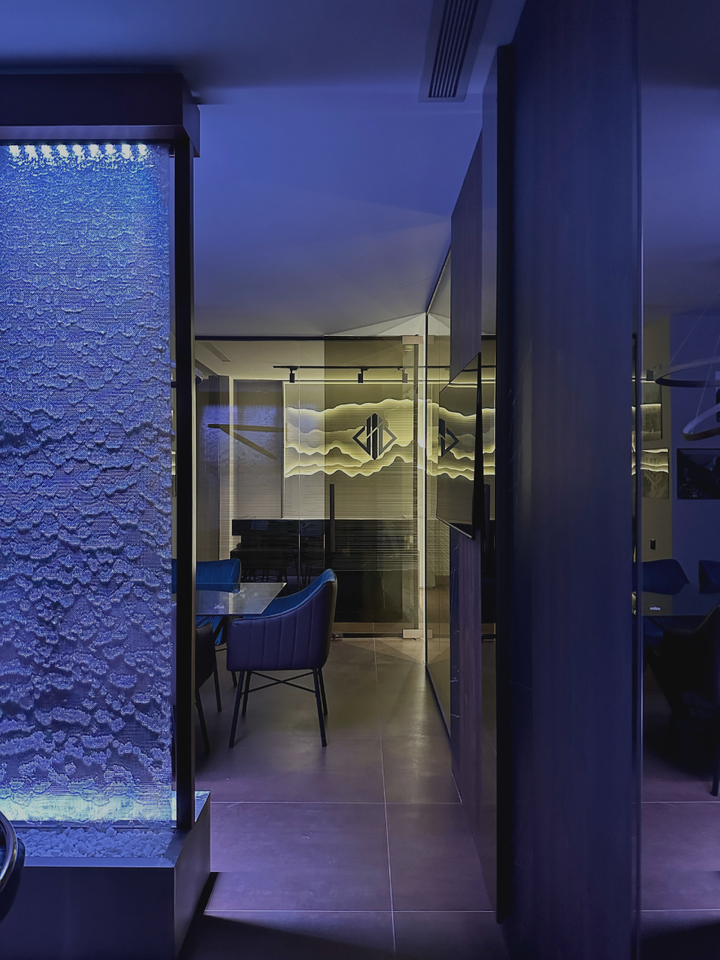 Birou UpBuild cu coloană de apă iluminată albastru și sală de ședințe în spate