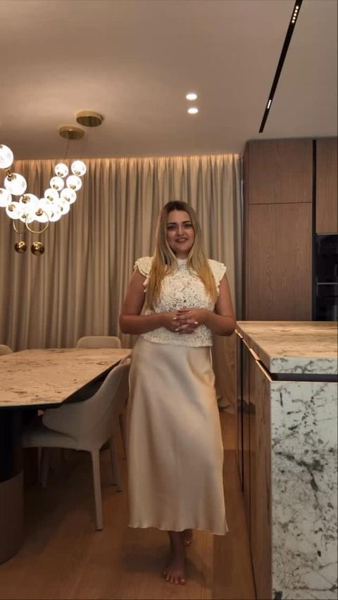 Designeriță în zona de luat masa, lângă o lustră cu sfere