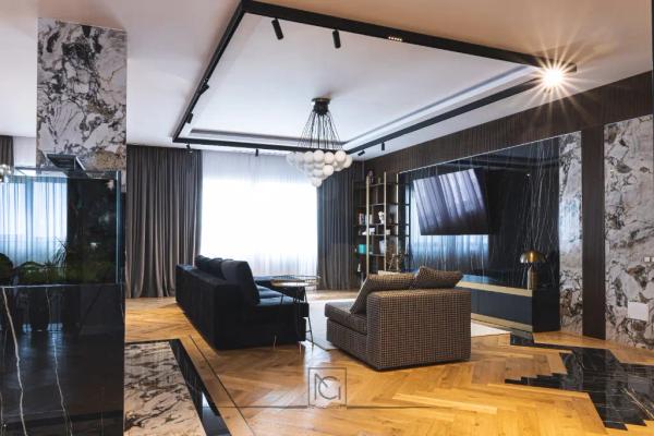Living cu acvariu încastrat în coloană de marmură, canapele închise și lustră cu globuri – Penthouse B. V., București