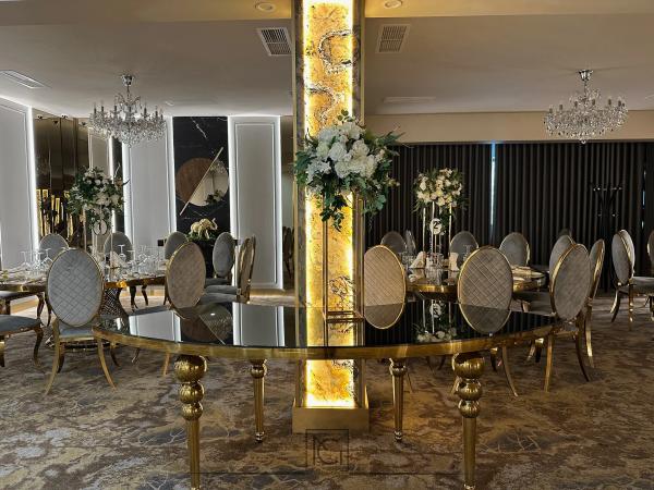 Salon de nunți cu mese aurii, scaune capitonate, lustre de cristal și coloană din onix iluminat