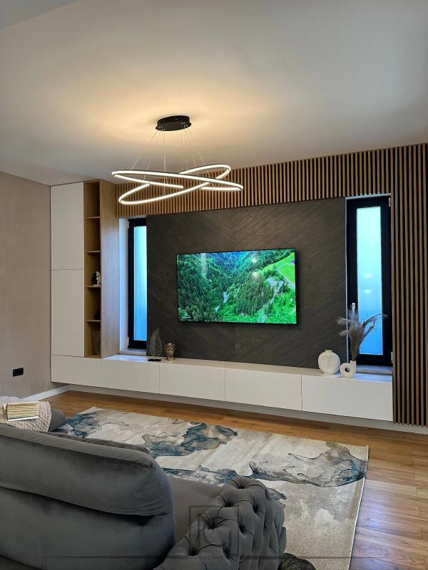 Living cu lustră inelară LED, covor abstract și comodă TV albă suspendată – Casa A.M., Alexandria