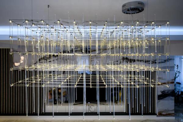 Lustră modernă amplă din tije metalice și cristale, deasupra livingului