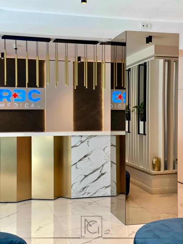 Recepție cu logo luminos, panouri din lemn închis și tuburi aurii – Romanian Bariatric Center, București