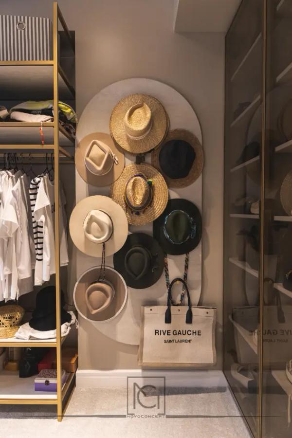 Perete de dressing cu pălării pe panou arcuit și rafturi aurii – Penthouse B. V., București