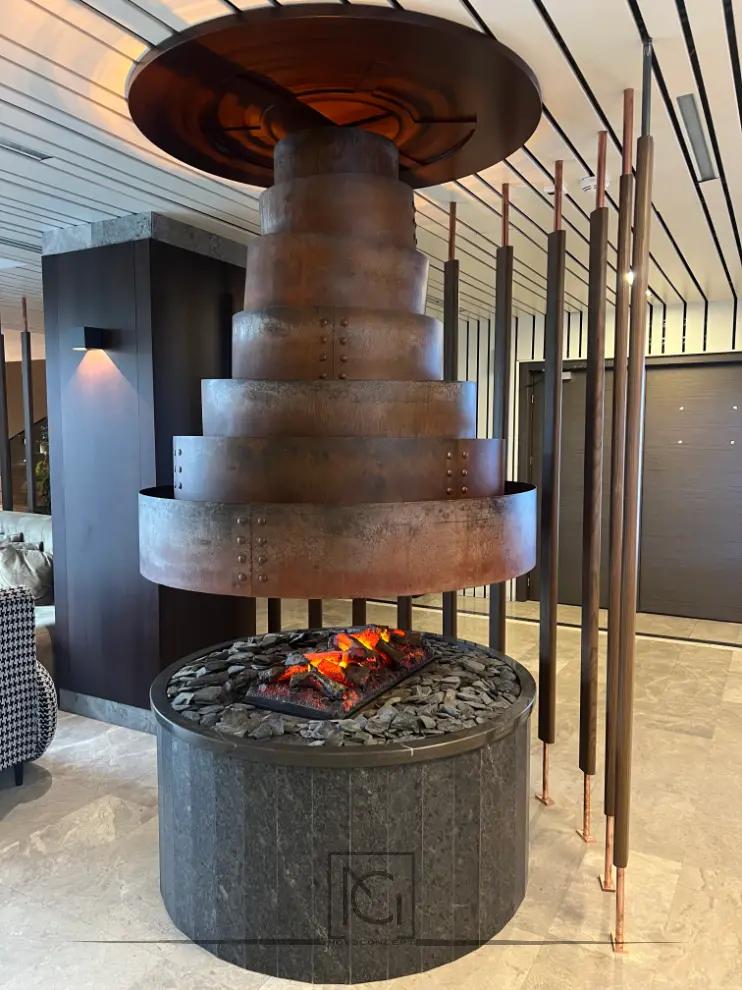 Șemineu central cu hotă din metal ruginiu în trepte, într-un restaurant cu lambriuri închise
