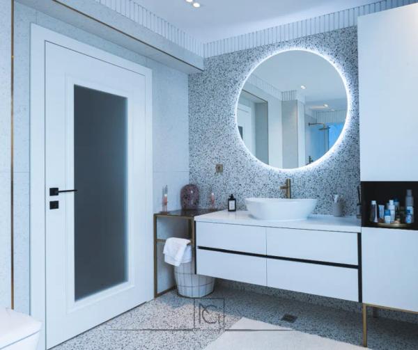 Baie cu terrazzo, oglindă rotundă cu LED și mobilier alb cu profile aurii – Penthouse B. V., București