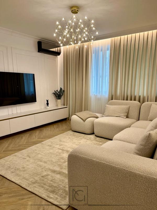 Living cu canapea modulară bouclé crem, comodă TV albă și lustră cu lumini în stea – Casa A.A., București