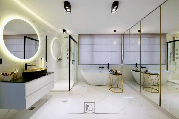 Baie cu lavoar negru pe blat alb, oglindă rotundă iluminată și cadă albă – Casa M.I., Bragadiru