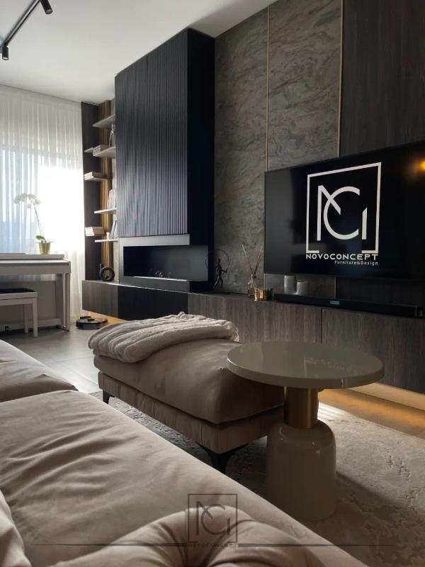 Perete TV cu piatră naturală, mobilier negru cu șemineu și măsuță rotundă bej – Casa A.M., Bragadiru