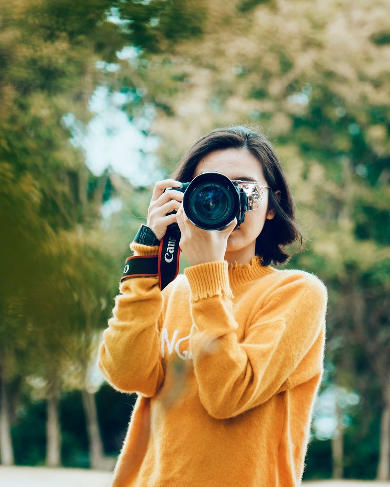Elena Martinez making a photograph with her camera in a park