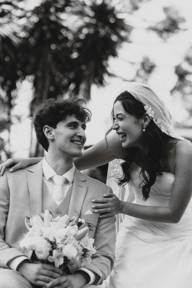 Black and white portrait of a bride and groom laughing together