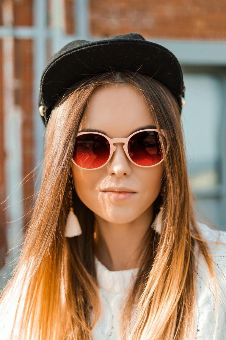 Portrait of a woman in a cap and round sunglasses