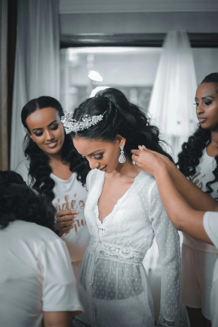 Bridesmaids helping the bride with her earring before the ceremony