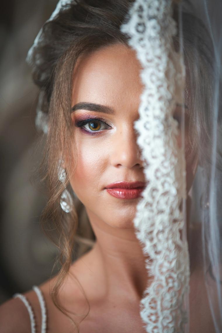 Close-up of a bride's face beside her lace veil
