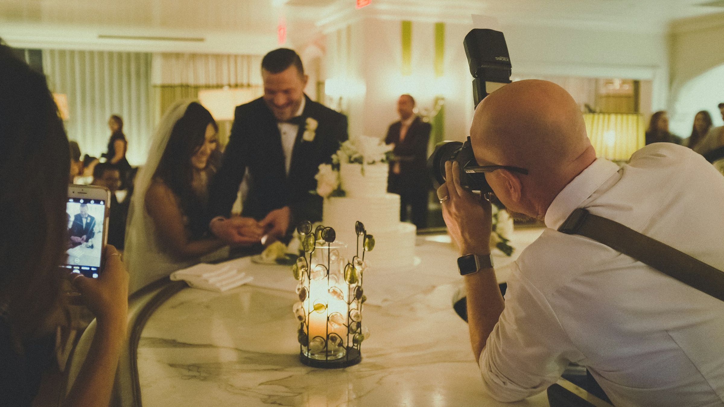 Photographer making a picture of the newlyweds at their reception
