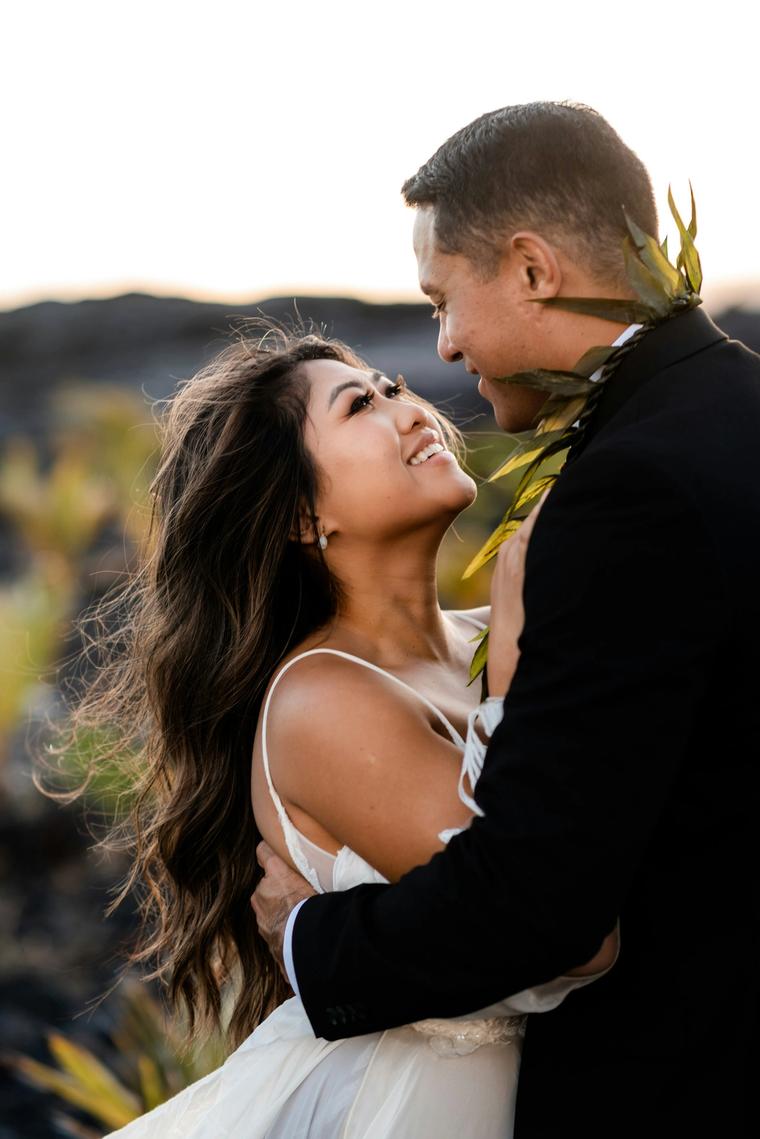 Bride and groom laughing face to face at golden hour
