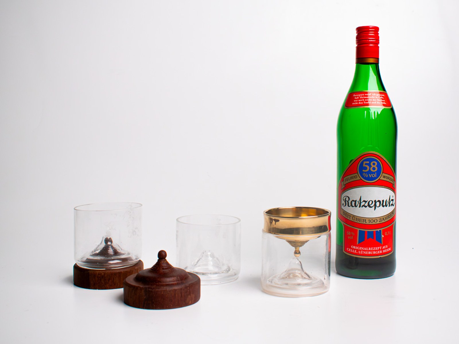 In Limbo — the two wooden-topped glasses and the brass chalice lined up beside the Ratzeputz bottle.