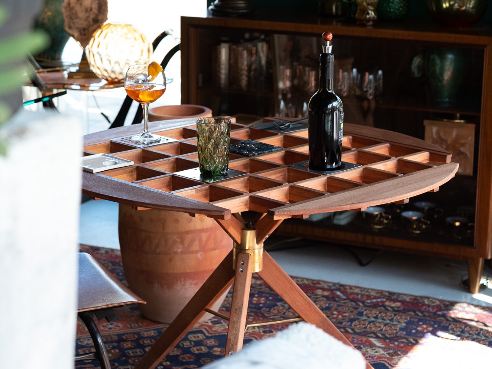 An Audience of Me — the table set with wine, a spritz, and a tumbler beside a terracotta vessel.