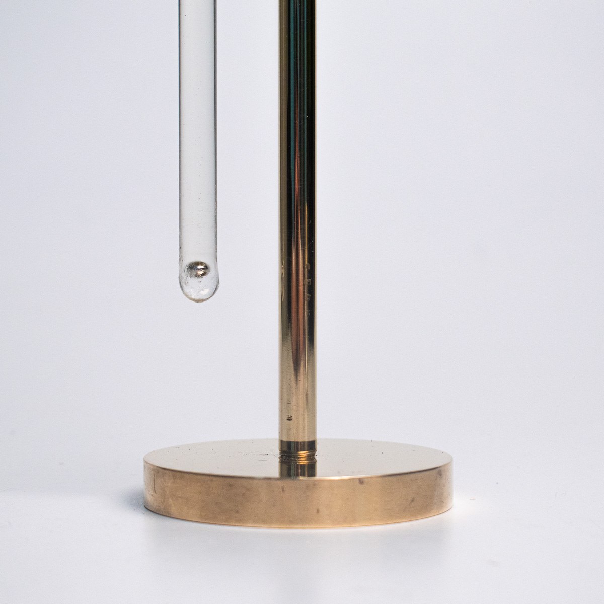 In Limbo — detail of the brass base and the glass rod rising from it.